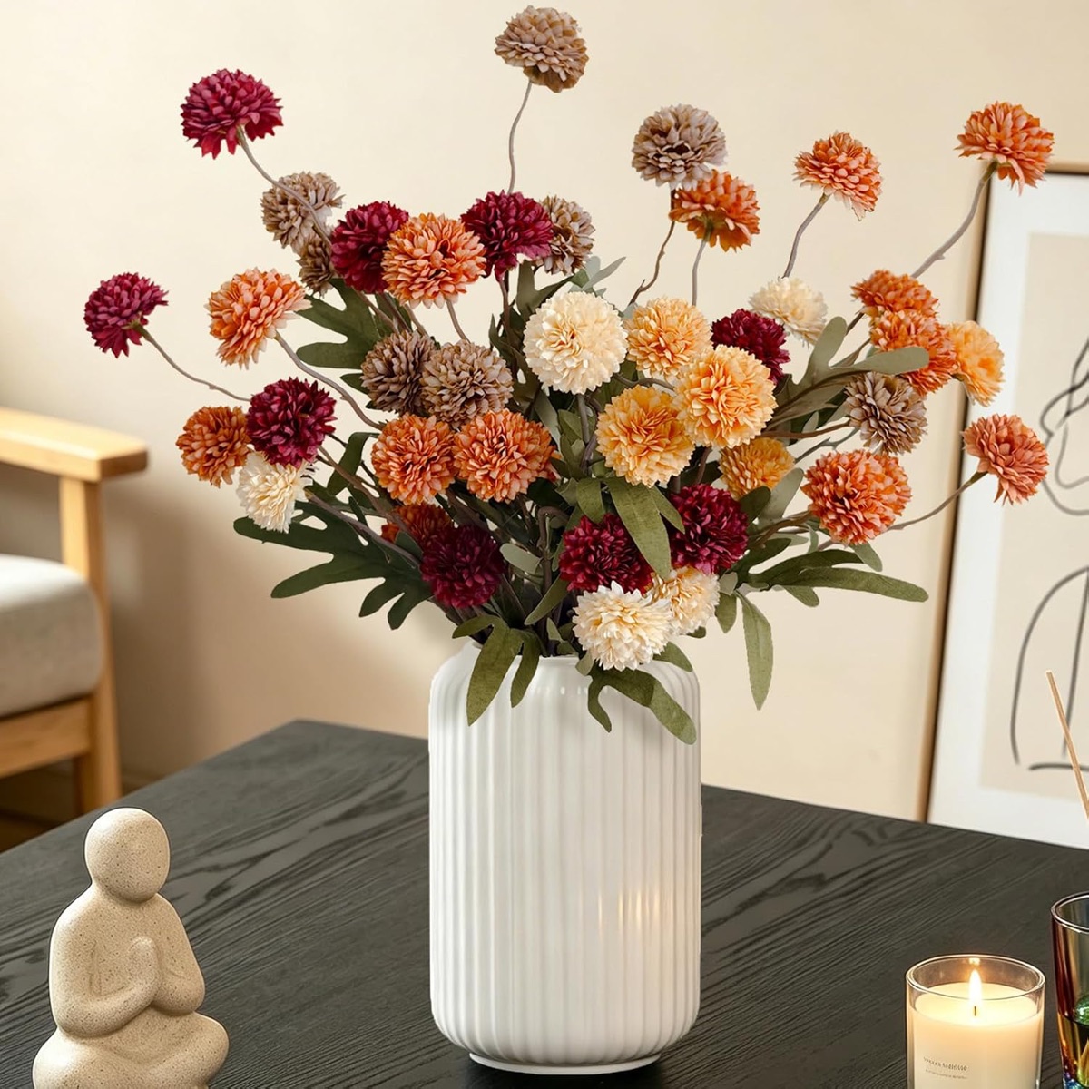Faux chrysanthemum stems in burgundy, burnt orange, peach, taupe and cream in a white ribbed vase